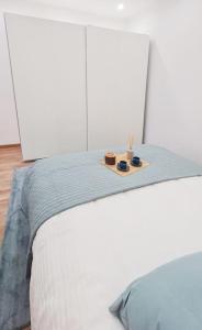 Una cama con una bandeja con dos velas. en Le Petit Cosy /Proche Disney - Paris / wifi - Netflix, en Meaux