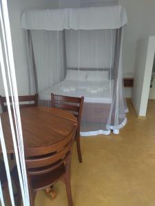 um quarto com uma cama e uma mesa e cadeiras de madeira em Colours of Life Home em Weligama