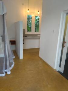 an empty room with two windows and a curtain at Colours of Life Home in Weligama