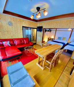 a living room with a red couch and a table at TOYA HOME kairou 一棟貸切 in Lake Toya