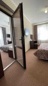 バコヴェルにあるKasimir Private Room 611, 612のベッド1台とガラスのスライドドアが備わるホテルルームです。