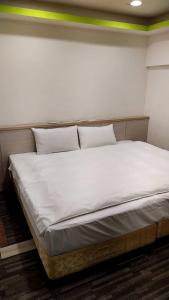 斗六的住宿－微旅時尚旅店，一张配有白色床单和枕头的大床