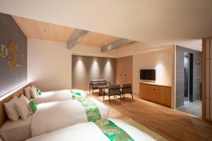 a hotel room with two beds and a table at Hotel Legasta Kyoto Higashiyama Sanjo in Kyoto