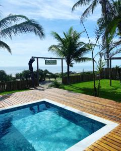 una piscina situata accanto a una terrazza in legno di Villa do Sossego - Caraíva a Caraíva