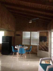 a room with a table and chairs and a kitchen at Herbert's Place in Cabo Rojo
