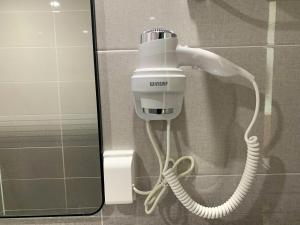 um secador de cabelo está ligado a uma parede na casa de banho em Aroomi Hotel Hyupjae em Jeju