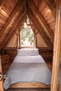 a bed in a small room with a window at Hawkay Glamping in San Miguel de Salcedo