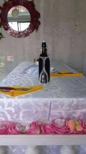Biały stół z umywalką i kwiatami w obiekcie Tinys Stayover w mieście Vosloorus