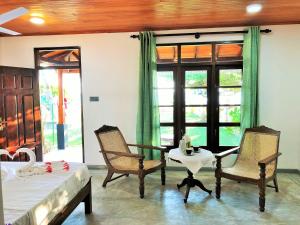 Habitación con 2 sillas, mesa y cama en Sunflower Beach Resort en Beruwala