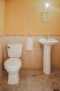 a bathroom with a toilet and a sink at Hotel Shinula in Huehuetenango