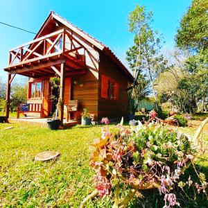 Une petite maison avec un bouquet de fleurs devant elle dans l'établissement Chalé Recanto Verde dos Canyons, à Praia Grande 41 autres photos