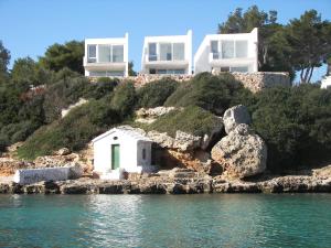 a house on a hill next to the water at Villa Cel in Cala en Blanes