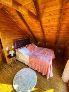 a bedroom with a bed and a table in a attic at Chalé Recanto Verde dos Canyons in Praia Grande