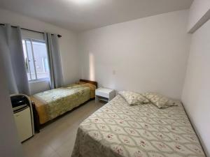 1 dormitorio con 2 camas y ventana en Apartamento Avenida Brasil, en Balneário Camboriú