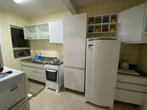 cocina pequeña con nevera y fogones en Apartamento Avenida Brasil, en Balneário Camboriú