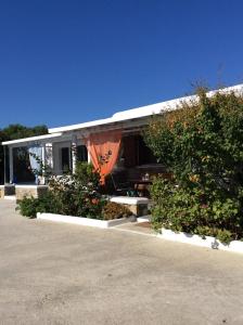 a house with some bushes and flowers in a parking lot at Liana Studios in Mýkonos City