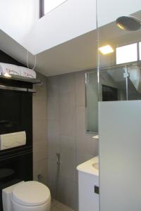 uma casa de banho com um WC branco e um lavatório. em The Southbridge Hotel em Singapura