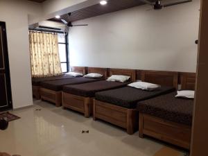 MahādKuber's Residency的带窗户的房间里的一排床