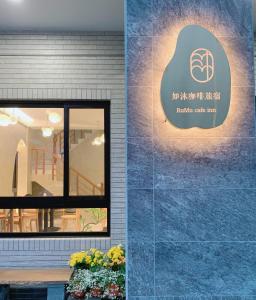un panneau sur le côté d'un bâtiment dans l'établissement 如沐咖啡旅宿, à Xingjian