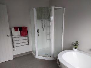 a white bathroom with a shower and a toilet at The Grey Studio@13a in Carterton