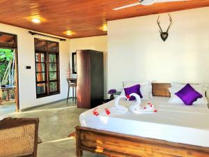 Un dormitorio con una cama con dos cisnes. en Sunflower Beach Resort en Beruwala