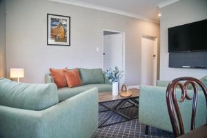 a living room with a couch and a table at Country Comfort Armidale in Armidale