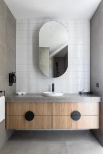 ein Bad mit einem Waschbecken und einem Spiegel in der Unterkunft Caroline Serviced Apartments Richmond in Melbourne