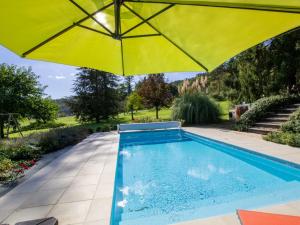 an umbrella over a swimming pool in a yard at Gîte Montignac, 5 pièces, 8 personnes - FR-1-616-218 in Montignac