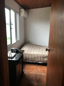 um quarto com uma cama, uma secretária e uma janela em Confortable espacio en Minas em Minas