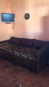 Bett in einem Zimmer mit einer Uhr an der Wand in der Unterkunft Confortable espacio en Minas in Minas