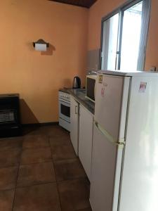 eine Küche mit einem weißen Kühlschrank und einem Fenster in der Unterkunft Confortable espacio en Minas in Minas