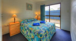 a bedroom with a bed and a dresser and a window at Sunlover Lodge in Kinka