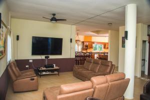 a living room with couches and a flat screen tv at RunAway to Tranquility, overlooking the Bay in Runaway Bay