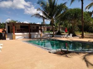 a swimming pool in front of a house with palm trees at Beautiful Flower Resort in Pak Meng