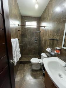 a bathroom with a toilet and a sink at Apartahotel Casa Soleil in Puerto Villamil