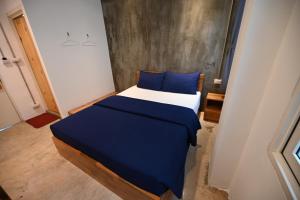 a bedroom with a large bed with blue pillows at Sribumpen Plus in Bangkok