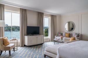 a hotel room with a bed and a flat screen tv at The Langham Sydney in Sydney