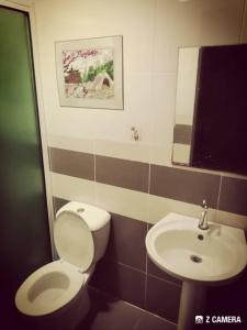 a bathroom with a white toilet and a sink at Kelly Homestay in Sibu +28 photos