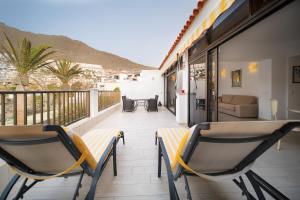 dwa krzesła i stół na balkonie w obiekcie OASIS BAY - Cliffs, Beach, Town center w mieście Santiago del Teide