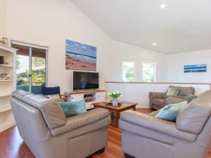 ein Wohnzimmer mit 2 Sofas und einem TV in der Unterkunft Summer Folly 1 in Blueys Beach