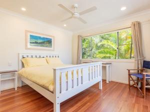 ein Schlafzimmer mit einem weißen Bett und einem Fenster in der Unterkunft Summer Folly 1 in Blueys Beach