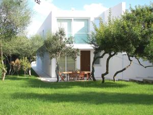 una casa blanca con una mesa en un patio en Villa Terra, en Cala en Blanes