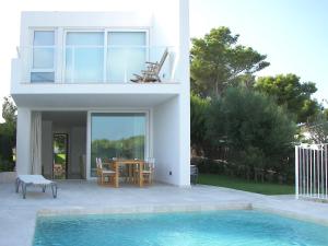 a house with a swimming pool in front of a house at Villa Terra in Cala en Blanes
