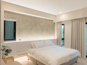 a bedroom with a white bed and a window at 如沐咖啡旅宿 in Xingjian