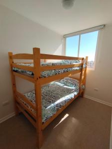 two bunk beds in a room with a window at Condominio Alto Hacienda in Coquimbo