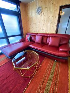 a living room with a red couch and a table at TOYA HOME kairou 一棟貸切 in Lake Toya