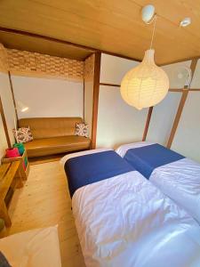 a bedroom with two beds and a bench at TOYA HOME kairou 一棟貸切 in Lake Toya