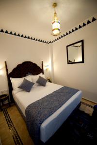 a bedroom with a bed and a chandelier at Dar Yasmine in Tangier