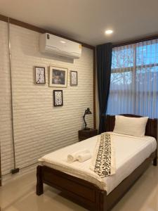 a bedroom with a bed and a window with a air compressor at Baan Suanfah Kiangdao in Nan