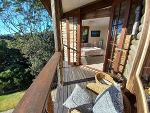 a porch of a house with a bed and a bedroom at The Junglehouse Noosa in Doonan